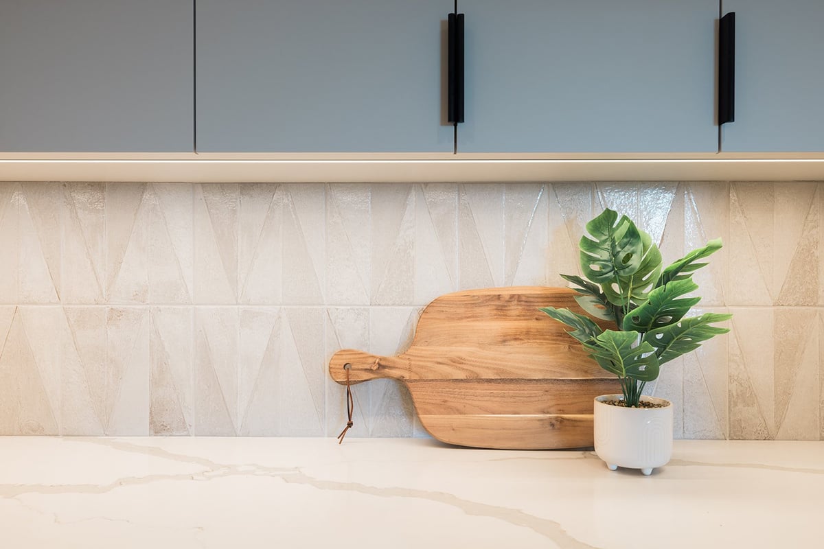Plant and cutting board on white countertop in Toronto kitchen condo renovation