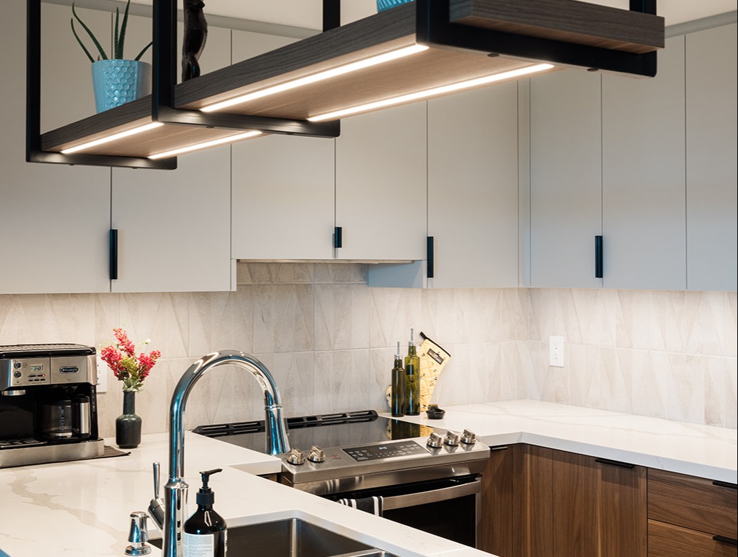 Under mount kitchen sink with stainless steel faucet in GTA condo renovation with hanging light fixture