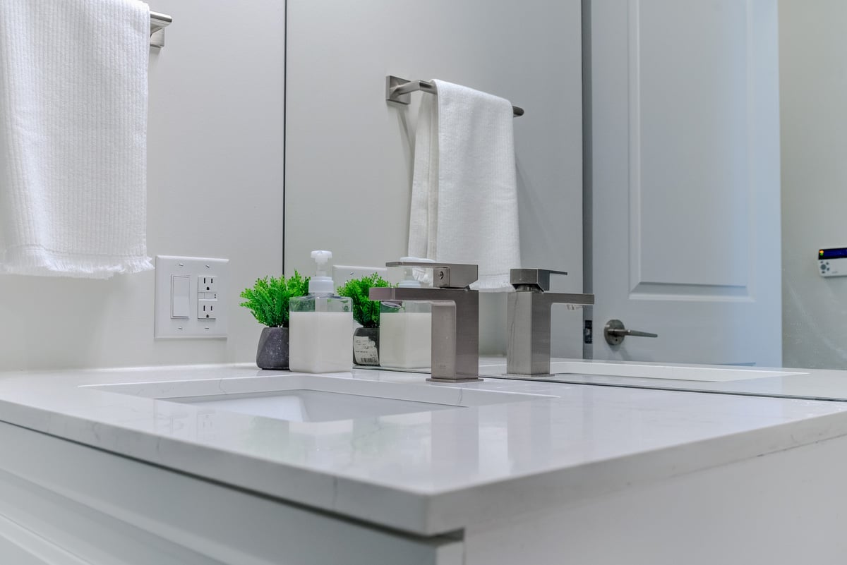 View of sink in condo bathroom renovation in the GTA with white countertop